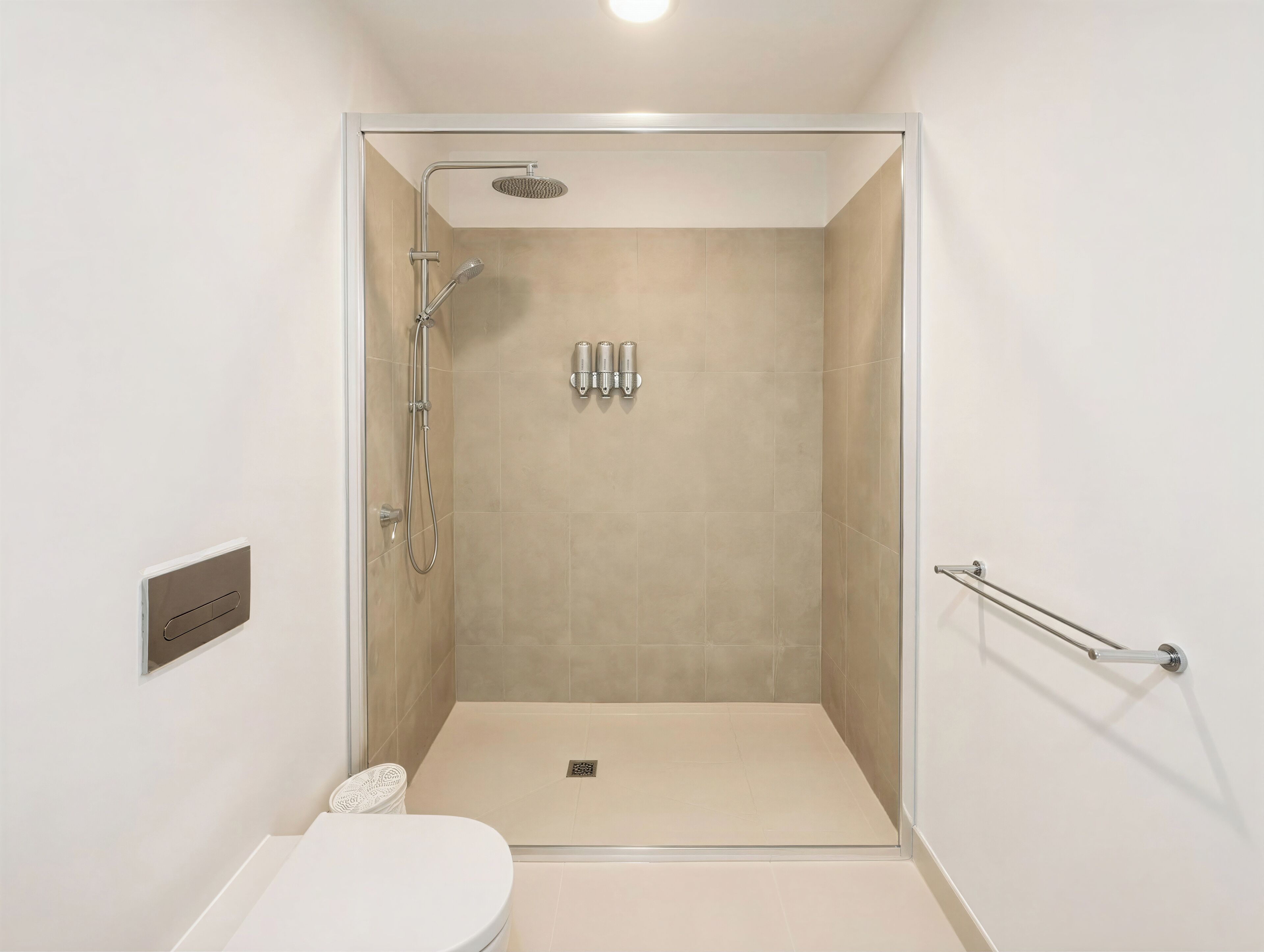 A modern bathroom with a walk-in shower, a toilet, and a handrail.
