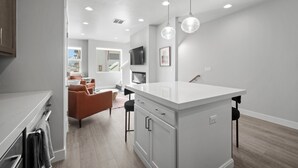 A modern kitchen with a central island, recessed lighting, and a dining area with a sofa and chairs. - Luxury 3 bed / 3 bath townhome in Park City, Sauna, 10 min to world-class skiing (Park City)