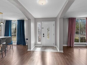 Step into a grand, welcoming entryway featuring beautiful hardwood floors and elegant glass accents.