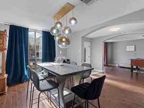 Sleek white table setup under a striking silver sputnik-style chandelier, surrounded by windows that fill the space with natural light. - Spacious & Stylish 4 BR house Round Rock (Round Rock)