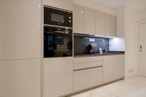 Une cuisine moderne dotée d’appareils électroménagers intégrés, d’un plan de travail et d’une porte sur laquelle est accrochée une serviette.