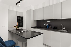 A modern kitchen with a black countertop, white cabinets, and a built-in oven.