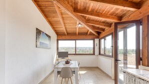 A room with a wooden ceiling, a dining table with chairs, a TV, and large windows. - Villa 'L'attico' with Sea View, Private Terrace and Wi-Fi (Castrignano del capo)