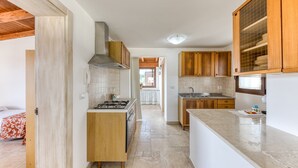 A compact kitchen with wooden cabinets, a gas stove, and a tiled backsplash. - Villa 'L'attico' with Sea View, Private Terrace and Wi-Fi (Castrignano del capo)