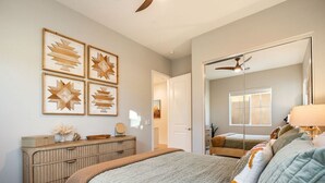 A bedroom with a bed, dresser, and wall art. - Fairway Gem: Pool+Spa, Putting Green, EV Charger! (Indio)