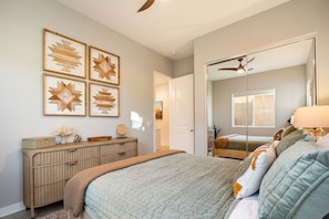 A bedroom with a bed, dresser, and wall art. - Fairway Gem: Pool+Spa, Putting Green, EV Charger! (Indio)