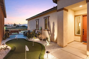 A residential property with a patio, a small lawn, and a house entrance.