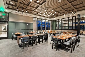 A restaurant with multiple tables, chairs, and a modern ceiling design. - Luxury Living in Deer Valley East Village | Poolside with Upscale Amenities (Park City)