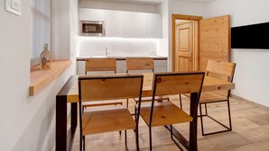 Une cuisine moderne avec des armoires blanches, un four à micro-ondes et une porte en bois.