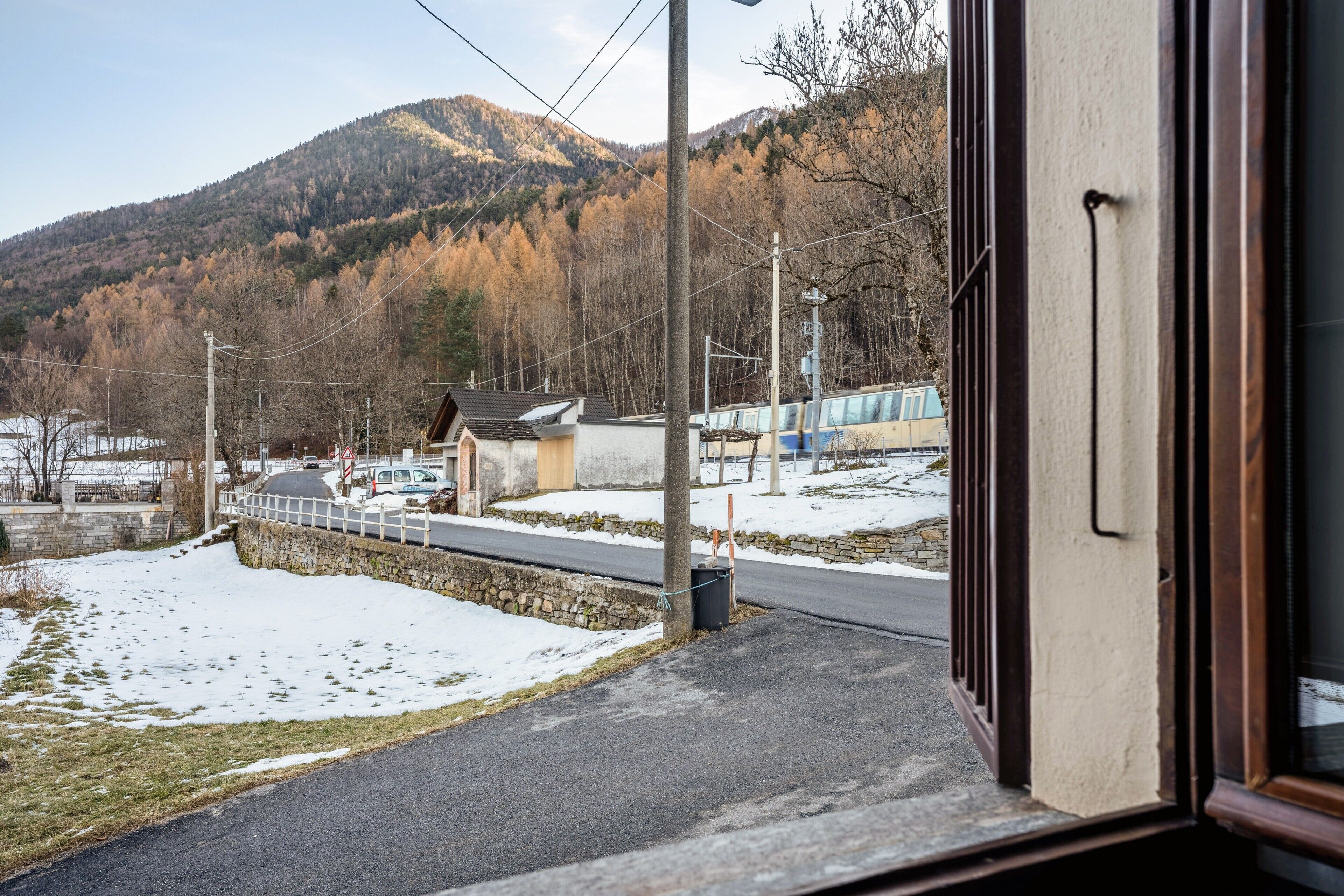 Vista desde el interior de un edificio hacia un paisaje nevado con una montaña al fondo.