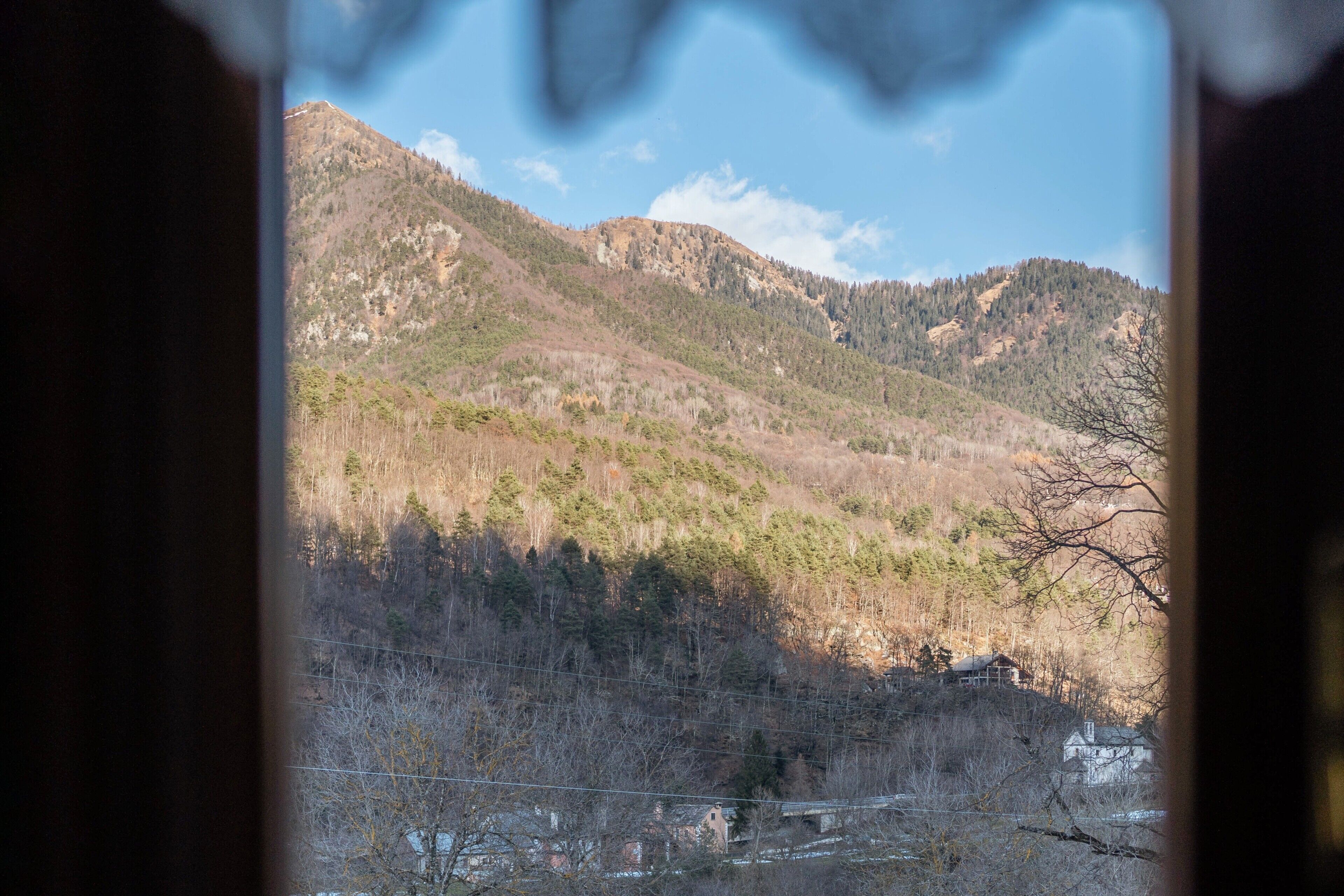 Un paysage montagneux avec une maison située sur une colline.