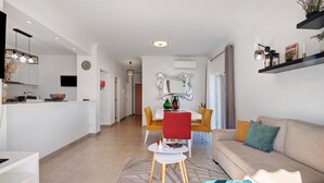 Ein modernes Wohnzimmer mit Küche, Essbereich und Sitzgelegenheit.