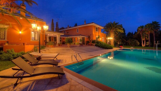 A swimming pool with lounge chairs, a covered patio, and a building with a tiled roof. - Villa 'Dependance' with Shared Pool, Wi-Fi and Air Conditioning (Lecce)