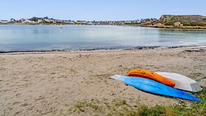Una playa con kayak y un mar tranquilo.
