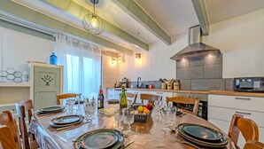 Comedor con una mesa dispuesta para seis personas, rodeado de sillas de madera.