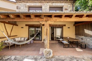 A patio area with a hammock, a wooden bench, and a table. - Country House 'Fuentebuena' with Mountain View, Private Terrace and Wi-Fi (Matabuena)