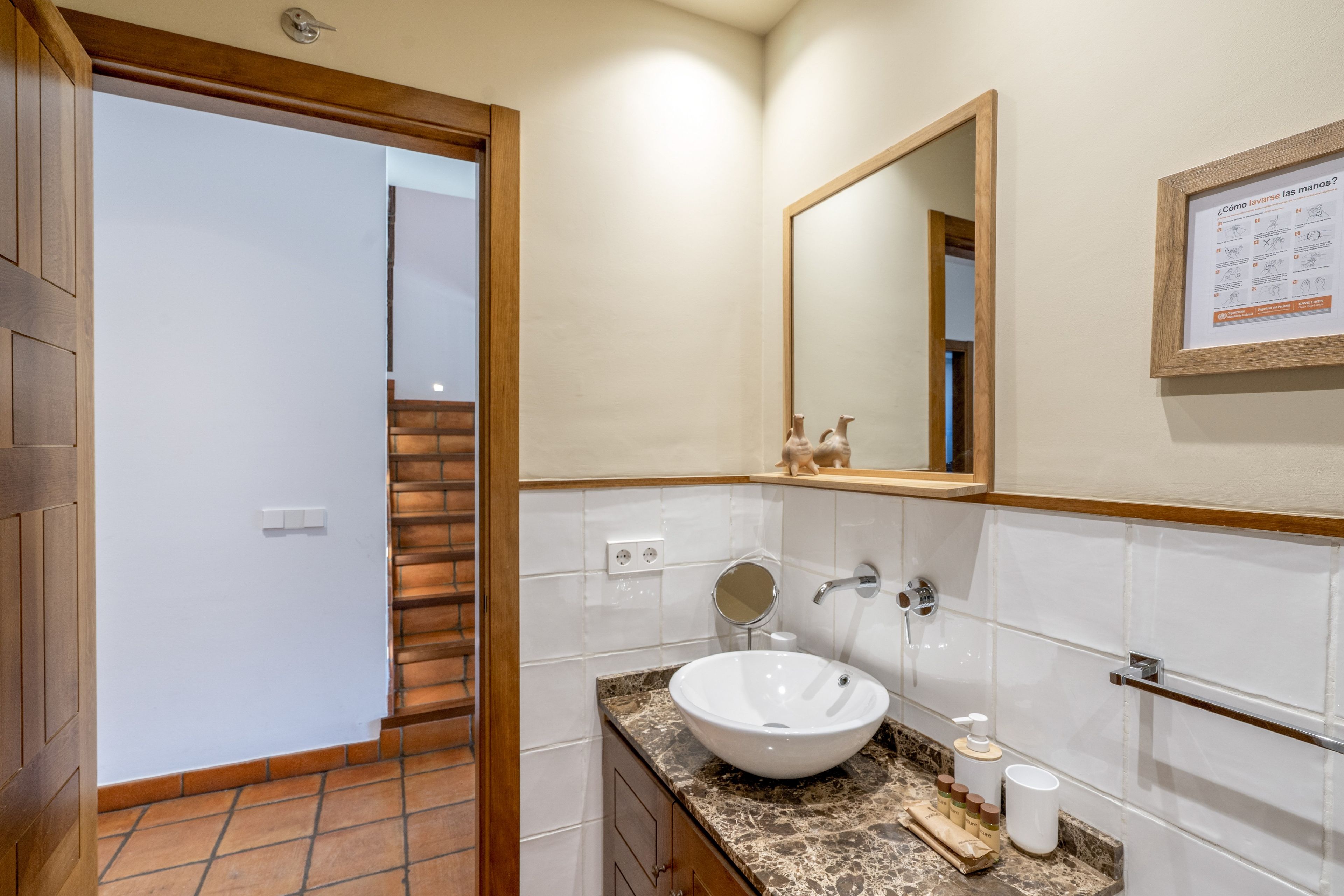 Een badkamer met een wastafel, spiegel en toiletartikelen.