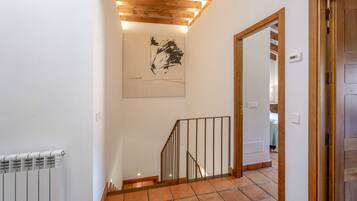 Escada com corrimão de madeira e obra de arte na parede.