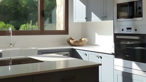 A modern kitchen with a window, stainless steel appliances, and a wooden bowl on the counter. - Country House 'Fuentebuena' with Mountain View, Private Terrace and Wi-Fi (Matabuena)