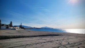 A beach with footprints, a clear sky, and distant mountains. - Apartment 'Ola De Mar' with Shared Pool, Wi-Fi and Air Conditioning (Estepona)