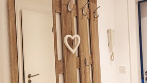Une porte en bois ornée d’un motif en forme de cœur et dotée de plusieurs crochets.