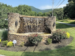 A stone structure with a waterfall feature and the text "Smoky Cove" on it.