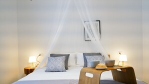 A neatly arranged bedroom with a bed, bedside tables, a bedside lamp, and a bedside table with a bowl and a plate. - Villa 'Casa Giò' with Private Pool, Wi-Fi and Air Conditioning (Santa Maria del Focallo)