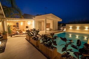 A modern house with a swimming pool, outdoor seating, and a well-lit patio area. - Villa 'Casa Giò' with Private Pool, Wi-Fi and Air Conditioning (Santa Maria del Focallo)