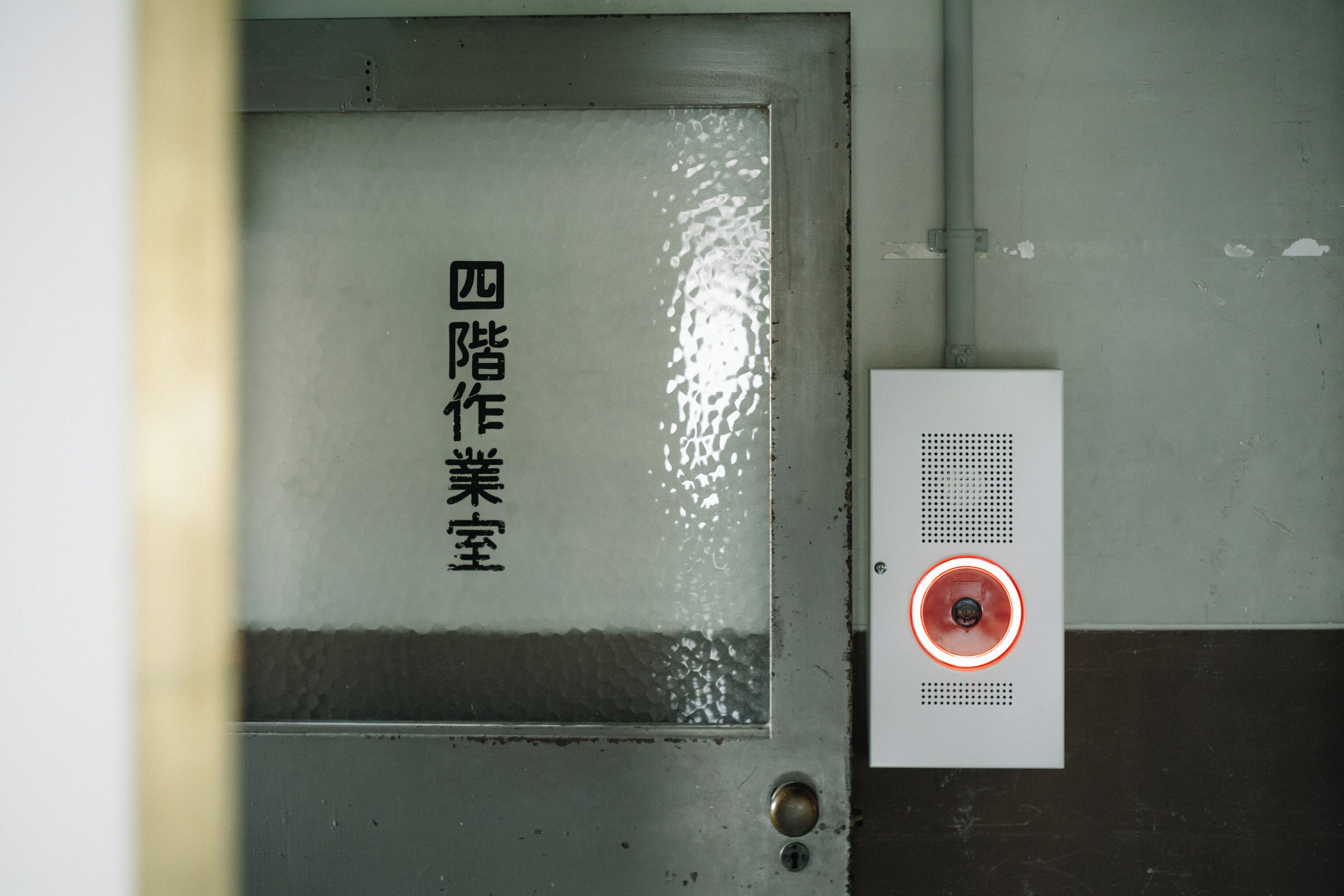 A door with a reflective surface and a sign with Chinese characters.