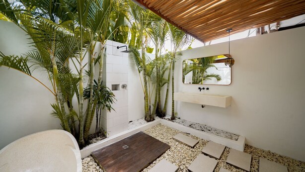 Ein modernes Badezimmer mit Dusche, Waschbecken und Spiegel.