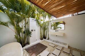 Un baño moderno con ducha, lavabo y espejo.