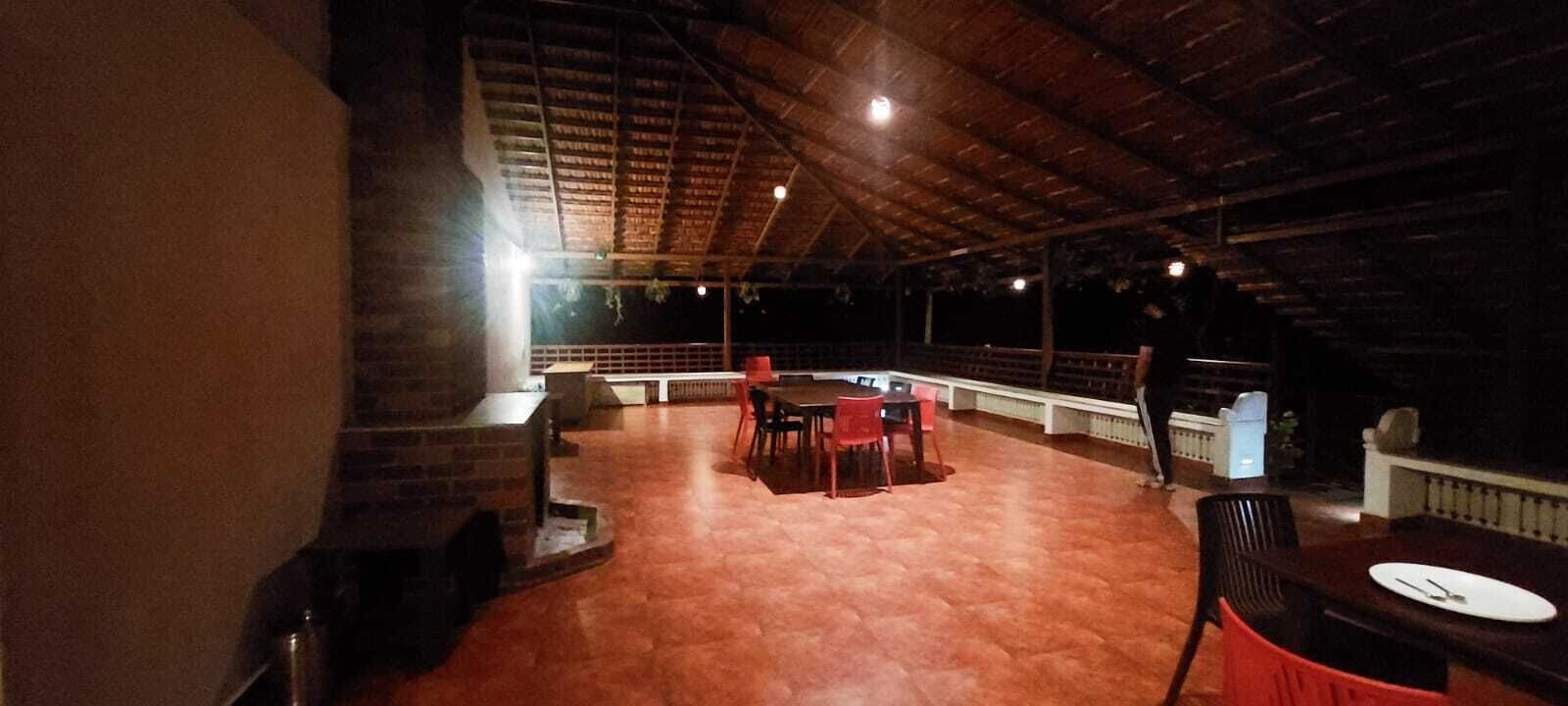 An outdoor dining area with brick flooring and a wooden ceiling.