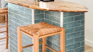 Una cocina con barra que incluye un grifo, taburetes y un adhesivo mural con la imagen de una furgoneta.