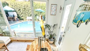 Una cocina moderna con una isla de madera, un lavaplatos empotrado y vistas a una piscina.