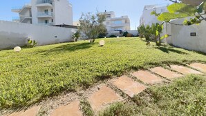 A residential area with modern buildings, a grassy lawn, and a tree in the foreground. - La Torre by Interhome (Ugento)