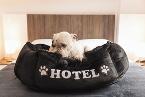 Guests' furry friends can rest comfortably in this cozy bed with a hotel-themed design.