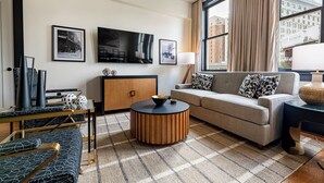 A modern living room with a sofa, a coffee table, and a TV mounted on the wall.
