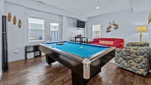 A pool table in a room with a red sofa and a patterned armchair. - CB49 - Cruisin' The Dunes, Gated Corolla Townhome w/ Hot Tub & Resort Pool (Corolla)