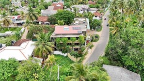 Un quartier résidentiel avec des maisons, une route et des palmiers.