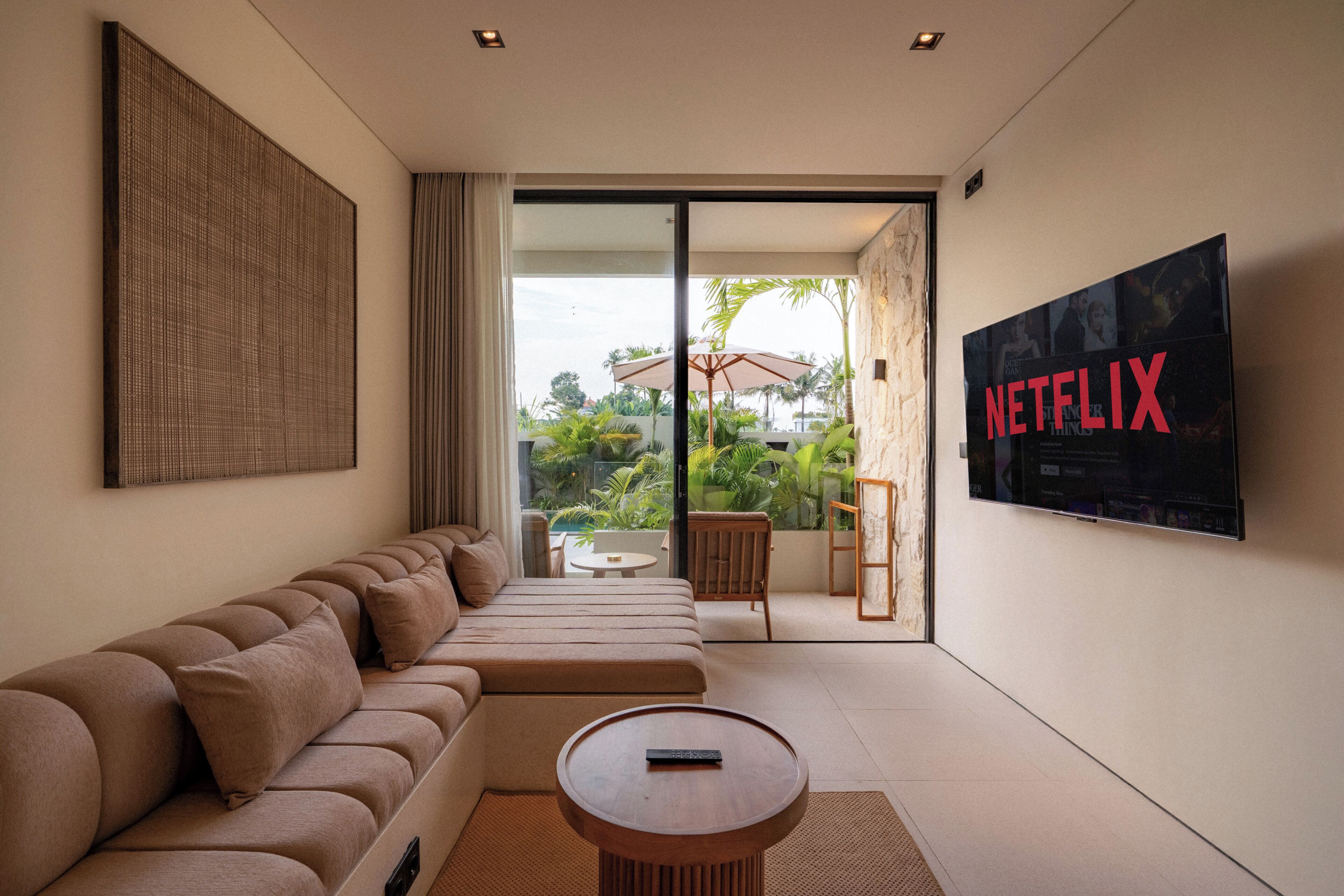 Ett modernt vardagsrum med en soffa, ett soffbord och en stor skärm som visar Netflix-logotypen.