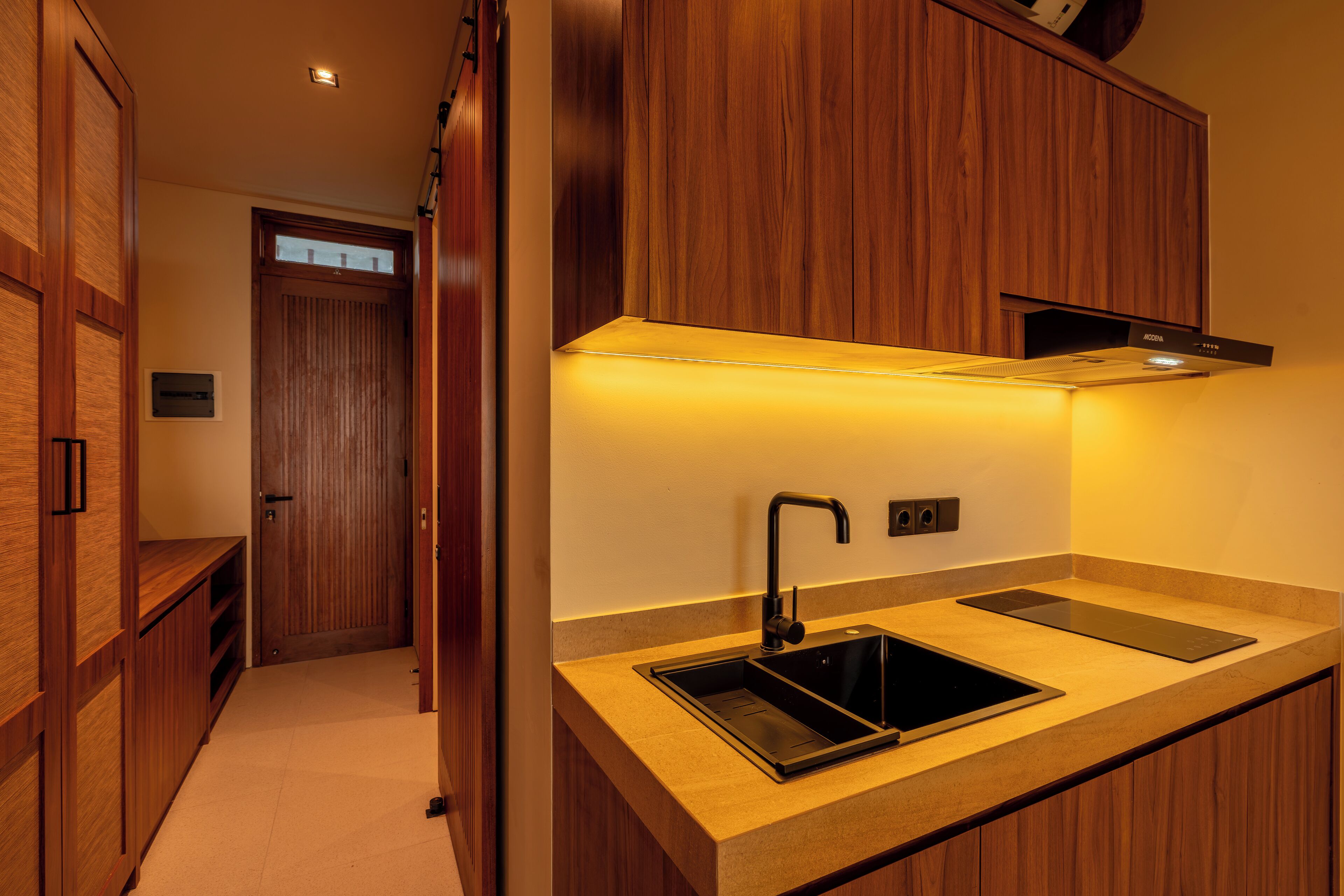 A modern kitchen with wooden cabinetry, a black sink, and a countertop.