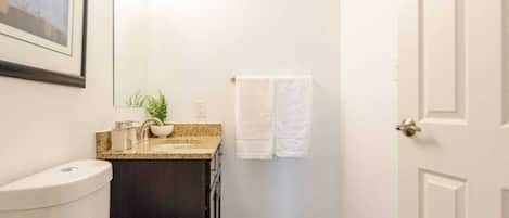 Een haardroger, handdoeken, zeep, toiletpapier