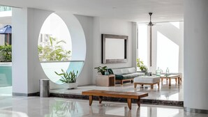 Eine moderne Lobby mit einem grünen Sofa, einem Holztisch und Topfpflanzen.