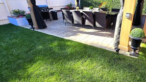 Une terrasse extérieure dotée d’une pergola, d’un barbecue et de mobilier d’extérieur.