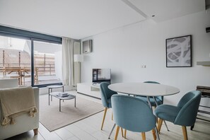 Relax in this stylish living room with a large window, flat-screen TV, and comfortable sofa.