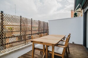 Enjoy an outdoor space with a table and chairs, surrounded by a fence and a building with a covered area.