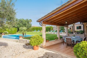 A covered patio with a pool, outdoor seating, and greenery. - REYNES - Rustic villa with private pool and free Wi-Fi (Pollença)