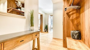 A wooden interior with a desk, a mirror, and a shelf with a plant. - Chalet GM - Gardenappartment (Brand)