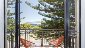 A balcony with two orange chairs, a metal railing, and a view of a building labeled "BOATHOUSE" in the background. - Terrace Heaven – Luxe Retreat in Fremantle (Fremantle)