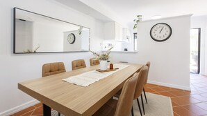 A dining area with a wooden table, six chairs, a large mirror, and two wall clocks. - Terrace Heaven – Luxe Retreat in Fremantle (Fremantle)